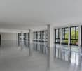 modern interior, gray floors, white walls, large glass windows, view to the outside