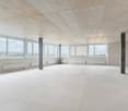 Empty room, white tiles, large windows, concrete pillars, white radiators