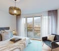 large bed, pillows, blanket, rug, chair, table, lamp, pendant light, sliding glass doors, balcony, view