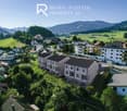 Residential area with houses, villas, and apartment buildings in a picturesque rural setting.