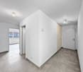 Empty room, white walls, tiled floor, two doors, small windows.