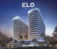 Twin luxury high-rise residential buildings with modern architecture, surrounded by lush greenery, set against a backdrop of a clear blue night sky.