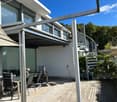 White building, large windows, spiral staircase, spiral metal railing, outdoor seating area, metal railings, spiral stairs, garden view