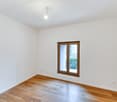 empty room, white walls, wooden floor, single window, light fixture
