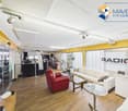 wooden floor, white ceiling, large windows, multiple furniture items
