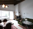 wooden ceiling, fireplace, dining table, green couch, carpet, lamp