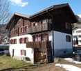 2 story wooden house, red shutters, balcony, snow on ground