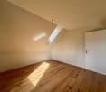 wooden floor, white walls, skylight window, door, small power outlet