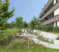 A garden with a variety of flowers, plants, and trees. There are wooden benches and a concrete pathway. A building with balconies is visible in the background.