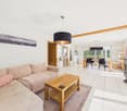 white walls, beige sofa, wooden coffee table, white tiles, fireplace, dining table and chairs, picture on the wall