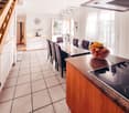 Dining room with a large table, chairs, and a bowl of fruit on the counter