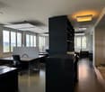 modern office space with desks, chairs, cabinets, and windows
