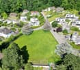 an aerial view of multiple houses in a neighborhood with green grass and trees