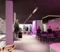 Modern and stylish interior space with concrete walls, purple lighting, and various seating areas. The space features a balcony or terrace visible through the windows.