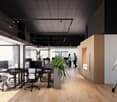Open office space with workstations, wooden floors, black and white decor, track lighting, and a potted plant