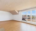 empty room, wooden floor, white walls, large glass doors leading to balcony, view of houses and trees