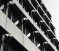 modern design, multiple floors, many windows, concrete exterior, balconies