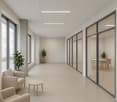 wide hallway, large windows, 2 couches, table, plants, polished tile flooring
