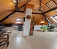 wooden ceiling, wooden floor, chandelier, desk, chair, plants, wheel, table
