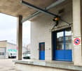 white brick walls, blue glass doors, sign, metal overhead crane