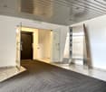 Entrance with glass doors, carpeted floor, metal directory, elevator, and a glass wall.