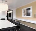 modern office room, white walls, beige wall, white table, black chairs, white shelf, modern lamp, picture frame
