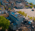 Aerial view of city buildings, open square, and waterfront