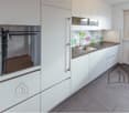 modern white kitchen, stainless steel oven, granite countertop, sink with faucet, wooden floor