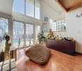 large windows, wooden floor, glass doors, Buddha statues, bean bag chair, wooden cabinet, plants, swimming pool view