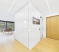 modern interior, white walls, wooden floor, white doors, dining area with table and chairs, glass railings