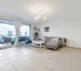 large glass door, balcony, white tile flooring, gray couch, white coffee table, chandelier