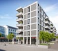 Modern apartment building with multiple balconies, glass windows, and a ground floor with commercial space.