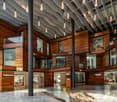 Modern building, wooden exterior, glass windows, suspended lights, spacious lobby, large entrance, multiple levels