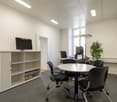 modern office room, white walls, gray floor, table, chairs, desk, computers, storage cabinet, indoor plant, lamp