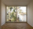 open sliding door to balcony, wooden parquet floor, white walls