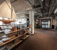 Model sailboat on the ceiling, books, a desk, glass walls and a television screen