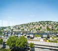 Apartment building with green roofs and a hillside view