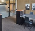 open space with tables, chairs, lamps, framed wall art, sliding glass wall, floor lamp, gray carpet