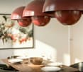 Dining room with wooden table, chairs, and red pendant lights