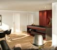Dining room with wooden floor, modern furniture, red cabinets, kitchen island, dining table, chairs, artwork, pendant lights, glass door