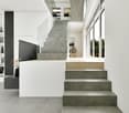 modern house with concrete and glass, large steps, glass railing