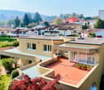 Detached house, modern design, red terracotta roof, outdoor terrace, swimming pool, large windows, mountain view