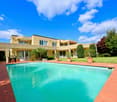 Large villa with pool, lawn, well-kept garden, yellow exterior, red roof, many windows