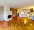 Living room with fireplace, wooden floor, white walls, kitchen