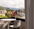 View from a balcony with table and chairs, potted plant