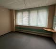 Empty room, blank walls, window with vertical blinds, wooden shelf next to the window