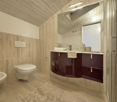 modern bathroom with white toilet, sink, and shower, wooden ceiling, tiled floor