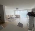 open layout, white couch, coffee table, chandelier, carpet, dining table, vacuum robot