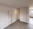 Empty room with white walls, white floor, and white radiator