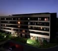 Modern apartment building with 6 floors, balconies, underground parking, and landscaped garden
